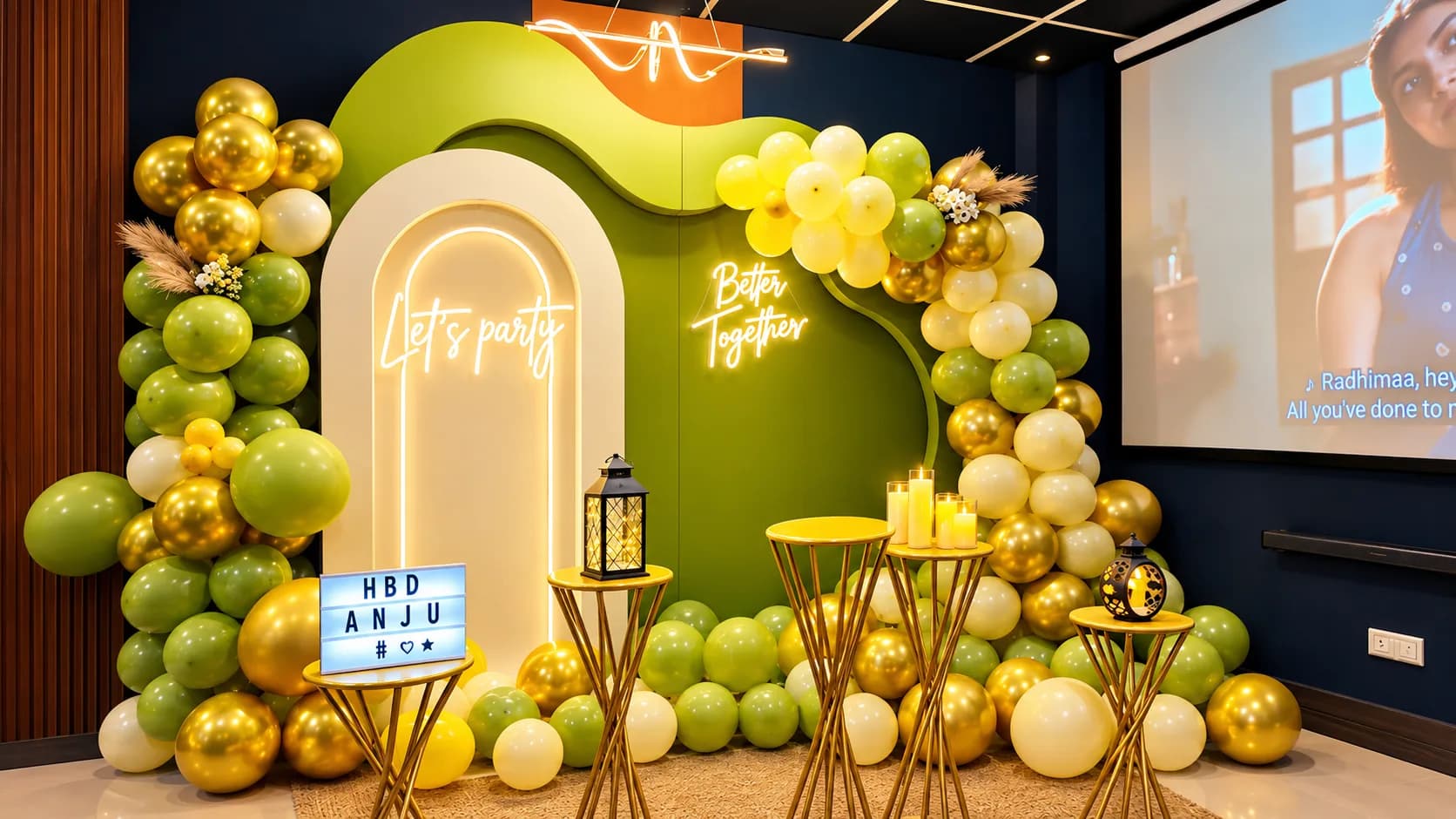 A green, gold and cream balloon arch around a lit cream arch panel with neon Let's Party and Better Together signs, gold candle stands and lanterns, beside the projection screen